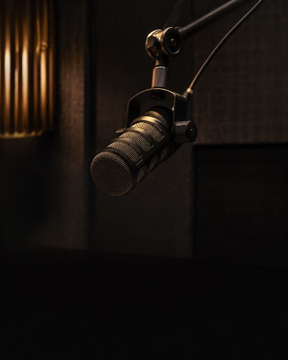 A studio microphone in a warm, intimate podcast setting